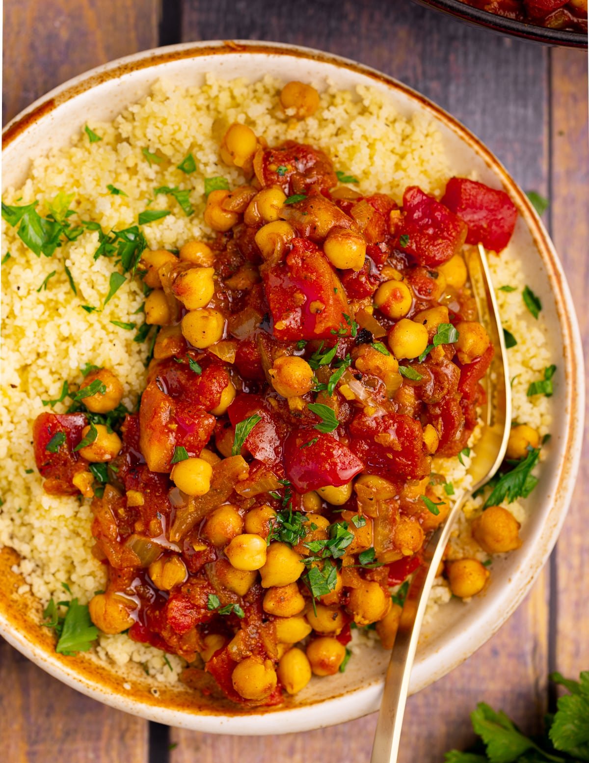 a bowl of smoky spiced chickpeas in tomato sauce over a bed of couscous 