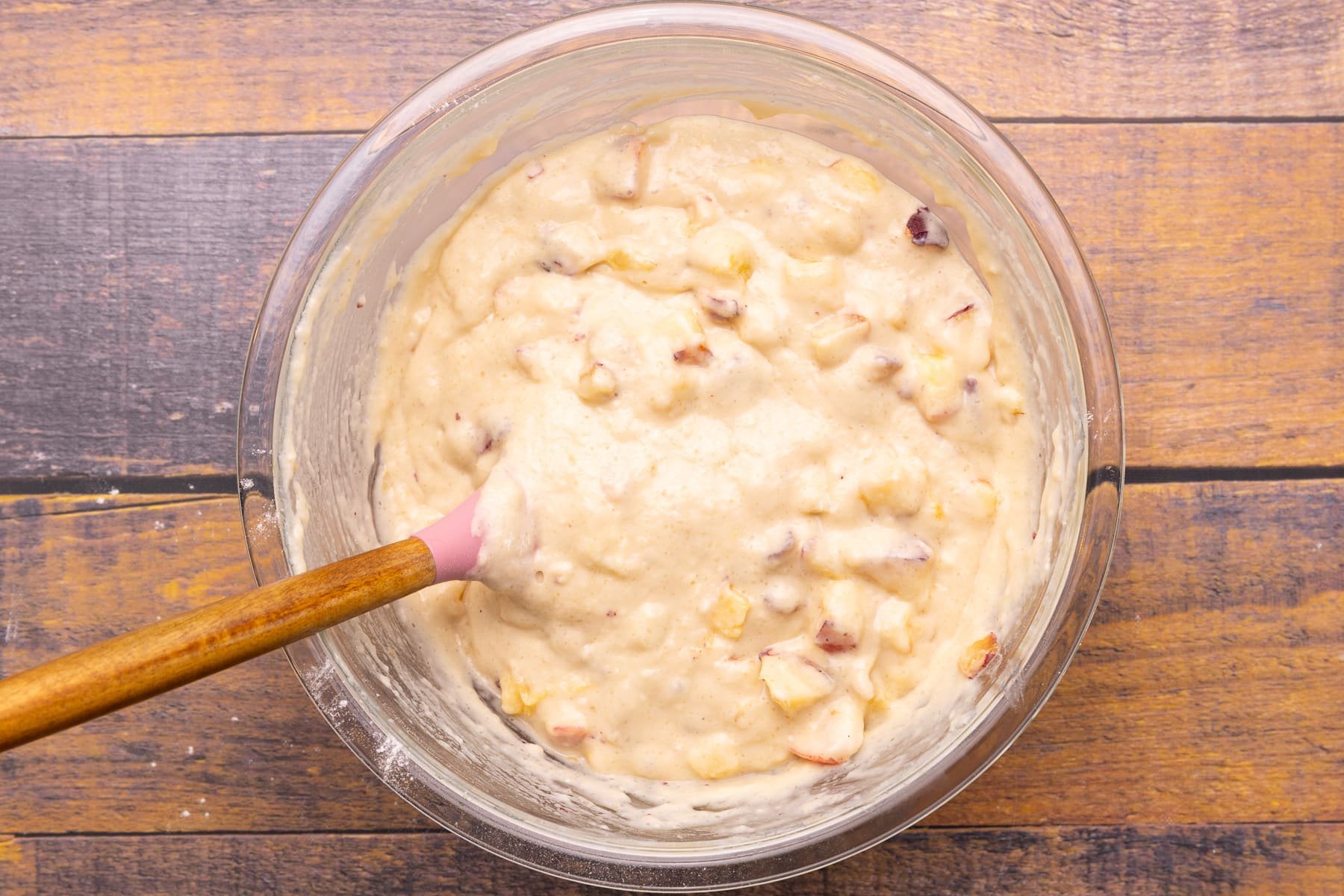 cake batter with peach pieces stirred through