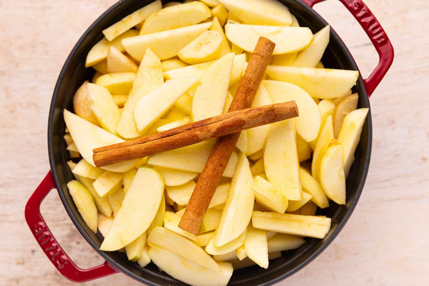 apples and cinnamon sticks in a pan