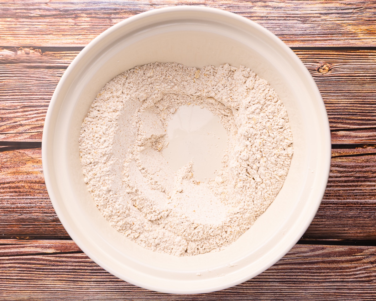 dry vegan Guinness bread ingredients mixed in abowl with a well in the middle