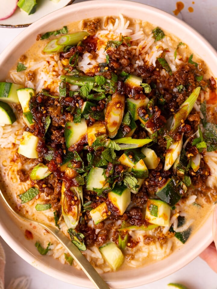 a hand holding a vegan brothy rice bowl