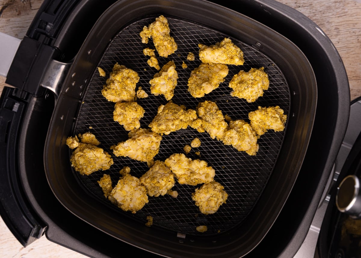 uncooked seasoned tempeh in an air fryer basket