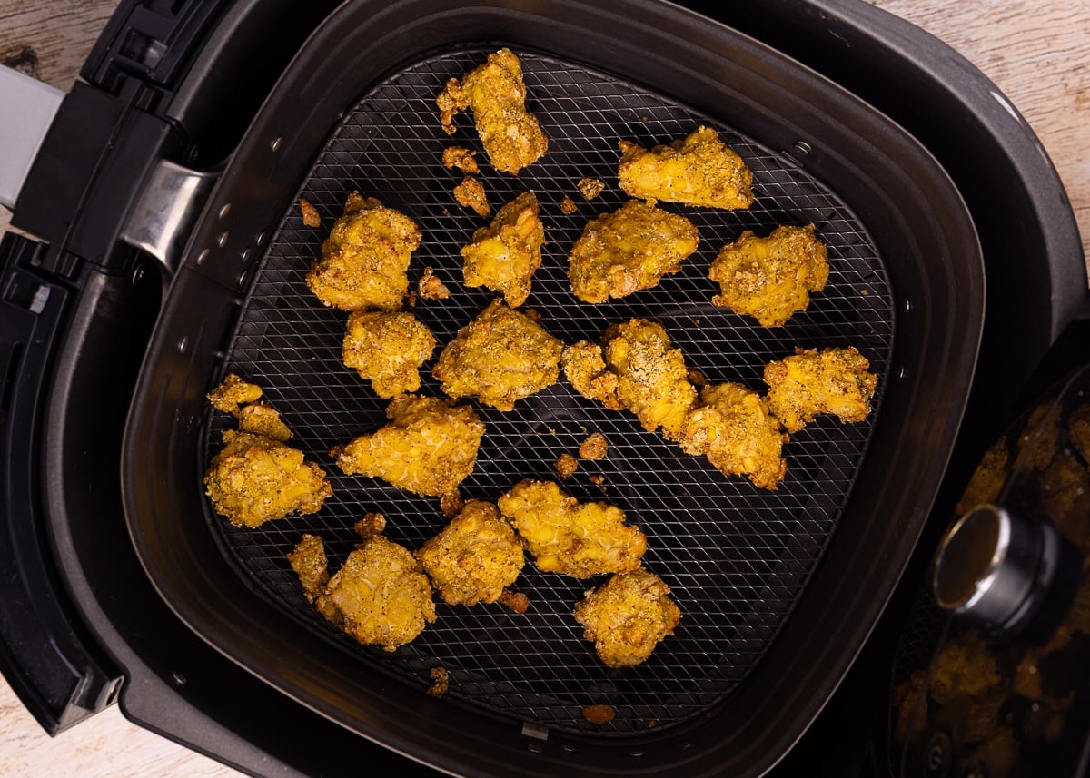 cooked nutritional yeast tempeh in an air fryer basket