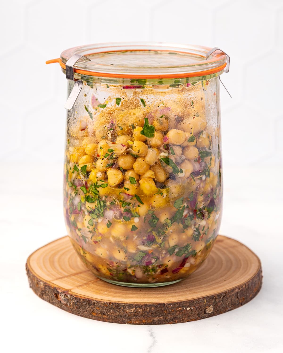 a jar of marinated chickpeas after mixing