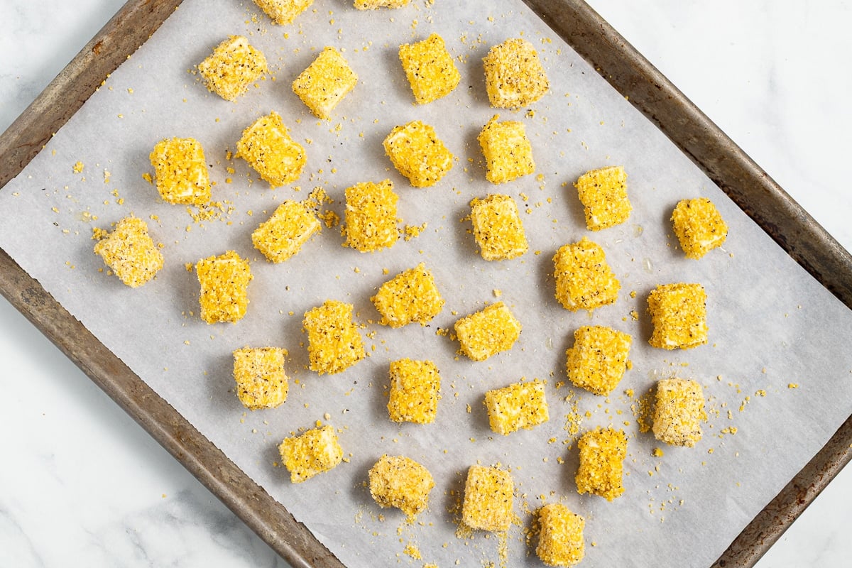 cornmeal coated tofu on a baking tray