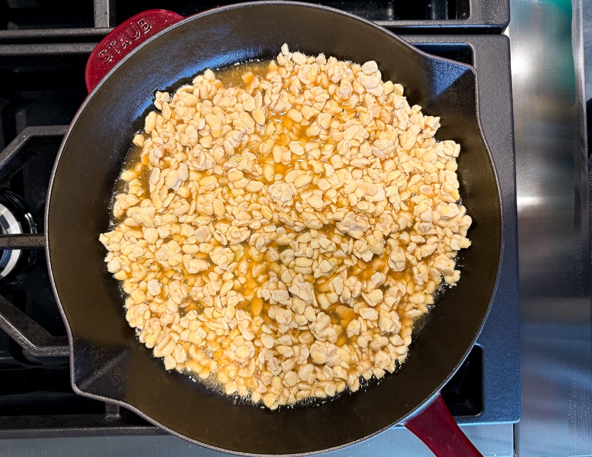 crumbled tempeh in stock in a skillet
